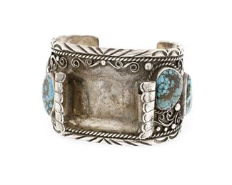 6126
A Southwest Silver And Turquoise Watch Cuff
Fourth-Quarter 20th Century
Stamped: FTA / Sterling
A cuff with six various sized heavy matrix turquoise set stones and applied filigree wire work overall
7.125" total inner C x 2" H, wrist opening: 1.25"
123.3 grams
Estimate: $200 - $300