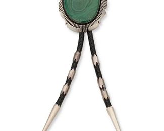 6130
A Thomas Byrd Red Mesa Malachite And Silver Bolo Tie
Fourth-Quarter 20th Century
Stamped: Thomas Byrd / Sterling / Red Mesa
A bolo comprised of a large domed malachite cabochon shadow set within a silver frame, with three pairs of ferrules and tapered silver tips, all on a black braided leather cord
Bolo: 3" H x 2.5" W
143.5 grams
Estimate: $400 - $600