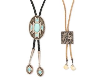6131
Two Southwest Bolo Ties
Second-Half 20th Century
Two works:

A bolo tie with an applied geometric element set with inlaid and stone set turquoise, with similar designed enhanced tips, all on black braided leather cord
Etched: SJG / '89 / ©
Bolo: 3.875" H x 1.875" W; Tips 3" L

A Hopi style bolo tie with figural overlay and wire wrapped and shell dangling tips, all on a tan braided fabric cord
Appears unmarked
Bolo: 1.375" H x 1.375" W

2 pieces
132 grams gross
Estimate: $300 - $500