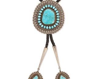6132
A Southwest Silver And Turquoise Bolo Tie
Fourth-Quarter 20th Century
Stamped: T [with a feather] / Sterling
A large bolo with a large central St Morenci turquoise and smaller turquoise surround with stamped border, finished with elaborate, dangling stone-set tips suspended from a black braided leather strap
Bolo: 3.25" H x 3.25" W; Tips: 4.5" L x 1.25" W
142.5 grams
Estimate: $300 - $500