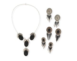 6177
A Group Of Southwest Onyx And Silver Jewelry
20th Century
Each marked: Sterling
Four works:

A silver necklace of linked sawtooth bezel set onyx cabochons, each topped with a silver foliate design
Further marked: N S
20" L x 3.5" H

A pair of concho-style earrings with central onyx cabochon and bead fringe
3" H x 1.25" W

A similar pair of concho-style post-back earrings with bead fringe
Further stamped: STC or STL
2.5" H x 1" W

A pair of concho-style stampwork silver earrings with bead fringe
3" H x 1.25" W

7 pieces
94.0 grams gross
Estimate: $200 - $300