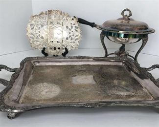 https://ctbids.com/estate-sale/13112/item/1172401 Silver Tone Serving Items
Heavy handled footed tray 24"x14.5", expanding trivet 11"x9" and a covered chaffing dish 10.5" in diameter x 10" tall and includes stand and burner. No visible markings. 