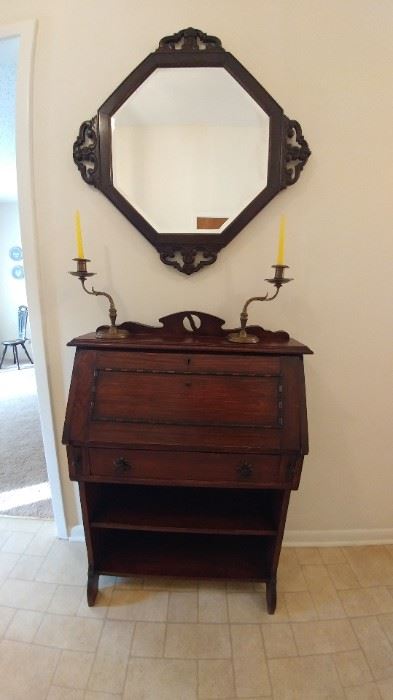 Antique small secretary. Beveled wooden mirror. Brass candlesticks.