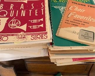 Lots of sheet music for piano, brass instruments.