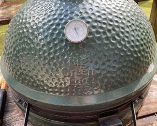 Green egg has had cover on it and sits in a table made for it 