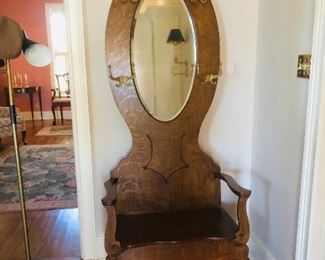 Victorian carved oak hall tree with beveled oval mirror