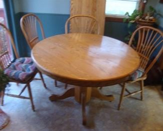 Solid oak table 48" diameter with a 20" leaf and 4 solid oak chairs