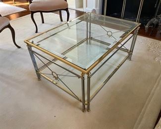 $1200  LABARGE DIRECTOIRE FRENCH GLASS TOP BRASS & STEEL COFFEE TABLE # LT0541

 WHY WE LOVE IT:

This polished steel and brass table is an example of modern day French Directoire style. Inset beveled glass top and a lower glass shelf for additional display area.  Exquisite detailed metal work in both silver an gold for a sophisticated aesthetic. 

 DETAILS + DIMENSIONS:

 26W X 37L X 18D inches
 LT0541
CONDITION: This piece is in very good condition.  There are no scratches or imperfections in the mirror or metal.  Please refer to photos for a more detailed look at condition.  We make every attempt to list and photograph any defects or signs of wear that are significant to this sale. 

LOCAL PICK UP ALEXANDRIA, VA.  BUYER IS RESPONSIBLE FOR ANY NECESSARY DISASSEMBLY AND ALL COSTS ASSOCIATED WITH SHIPPING OR PICK UP.  CONTACT US FOR SHIPPING RECOMMENDATIONS.