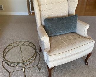 Upholstered armchair; brass-base side/accent table with glass top.