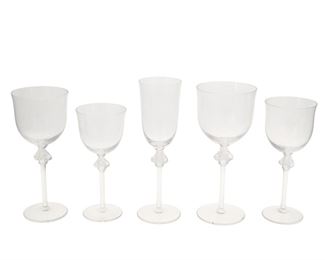 1017
A Set Of Lalique "Roxane" Stemware
Circa 1978-Present
Each etched to base: Lalique ® / France
Each clear crystal glass featuring a frosted detail of two entwined figures on the stem and scalloped beveling on the base of the chalice, comprising 7 tall water goblets (8.375"), 7 water goblets (7.875"), 13 fluted champagne glasses (8.75"), 13 burgundy wine glasses (7.5"), 13 bordeaux wine glass (6.875"), 53 pieces
Estimate: $2,000 - $3,000