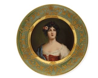 1053
A Royal Vienna Portrait Plate
Late 19th/Early 20th Century
Marked with blue underglaze Bindenschild; Further marked: Germany / Zigeunerin
The porcelain plate with a green and enamel gilt rim centering a portrait of a woman in traditional costume
1" H x 9.5" Dia.
Estimate: $1,200 - $1,800