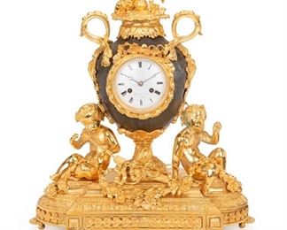 1087
A Guyerdet Aine Gilt-Bronze Clock
Mid-19th Century
Dial signed: Guyerdet Aine Paris
With a white porcelain dial with black Roman numeral hour markers and minute track, two train movement, surmounted by a gilt-bronze putto finial with scrolling foliage forming two handles on a metal urn-form body, upon an ornamental gilt-bronze base with floral motifs and two putto figures, raised on toupie feet
22" H x 19" W x 7" D; Dial: 4" Dia.
Estimate: $1,500 - $2,500