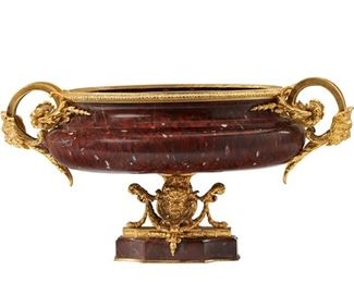 1091
A Gilt-Bronze And Marble Centerpiece
Late 19th/Early 20th Century
The gilt-bronze mounted, red marble centerpiece with an ovoid dish flanked by two scrolled handles with lion's masks, raised on a pedestal base with figural masks
12" H x 14" W x 11.5" D
Estimate: $3,000 - $5,000
