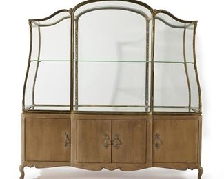1130
A Large Gilt-Bronze And Wood Vitrine Display Case
20th Century
The glazed, gilt-bronze case with mirrored interior and one shelf, over a wood console with three compartments fitted with pull-out shelves
81" H x 81.5" W x 28.5" D
Estimate: $2,000 - $3,000