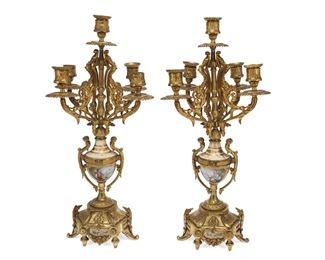 1147
A French Gilt-Bronze And Porcelain Mantel Clock And Candelabra Set
Circa 1889
Movement signed: Marti et Cie. [Samuel Marti] / Medaille d'Argent / 1889 / 21 20 / 6 4
The mantel clock with a painted porcelain dial, black Roman numeral hour markers, and two train movement enclosed in a glaze bezel and set in a gilt-bronze case with all-over scrolling foliate motifs and inset painted porcelain plaques, accompanied by two conformingly designed candelabra, 3 pieces
Clock: 19.5" H x 10.5" W x 4.5" D; Each candelabrum: 19.25" H x 8.5" W x 9" D
Estimate: $1,500 - $2,500