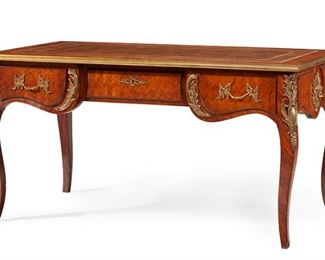 1151
A French Louis XV-Style Bureau Plat
19th Century
The parquetry veneered desk with inset gilt-foil stamped leather writing surface over a gilt-bronze mounted apron with rocaille motifs on three frieze drawers raised on four cabriole legs
30.25" H x 58.5" W x 32.5" D
Estimate: $1,200 - $1,800
