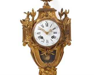 1171
A French Gilt-Bronze Cartel Wall Clock
Late 19th/Early 20th Century
The clock with a white porcelain dial, black Roman numeral hour markers and outer minute track, and two train movement with a glazed bezel set in a gilt-bronze case with laurel leaf boughs and birds surmounted by an urn finial and terminating with a figural mask, finished with pierced, floral motif side panels
24" H x 11" W x 4.75" D
Estimate: $800 - $1,200