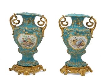 1213
A Pair Of Sèvres-Style Porcelain Vases
Late 19th/Early 20th Century
One marked with "MA" or "VW" [blue underglaze] and "VJ" [incised]
Each baluster-form centering pastoral themed painted reserves of pheasants, a bagpipe, straw hat, wheat, and scythe and decorated with enamel gilt highlights on a celeste blue ground, with opposed gilt-bronze handles and raised on a gilt-bronze footed support, 2 pieces
Each: 11.5" H x 7.25" W x 6.75" D
Estimate: $1,000 - $1,500