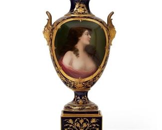 1242
A Royal Vienna Portrait Vase
Late 19th/Early 20th Century
Signed to bottom: La Rose 7671; With blue overglaze Bindenschild
The pine cone finial over a cobalt blue and gilt-highlighted body flanked by grotesque masks enclosing a portrait of a scantily clad woman raised on a stepped pedestal base
23.75" H x 10.25" W x 8.25" D
Estimate: $1,200 - $1,800