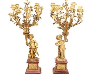 1248
A Pair Of Louis XVI-Style Gilt-Bronze And Marble Candelabra
19th Century
Each candelabrum in the form of a putto holding aloft a bouquet of naturalistic rose stems issuing five candle arms terminating in floriform capitals raised overall on a rouge marble pedestal with inset figural bas-relief panels and foliate borders atop four toupie feet, 2 pieces
Each: 31.25" H x 14" Dia.
Estimate: $3,000 - $5,000