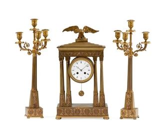 1256
A French Empire-Style Gilt-Bronze Mantel Clock And Candelabra Set
First-Quarter 20th Century
Movement signed: H&H / Made in France / G. Mégnin Medaille d'Argent [Georges Mégnin] / 2026 / 64
The mantel clock with white enameled dial, black Roman numeral hour markers and outer minute track, and two train movement, set in a gilt-bronze Empire-style architectural case in the form of a temple colonnade with anthemion border and surmounted by an eagle, accompanied by two conformingly designed candelabra, 3 pieces
Clock: 18" H x 10.5" W x 8.25" D; Each candlestick: 19.375" H x 7.5" W x 6" D
Estimate: $1,200 - $1,800