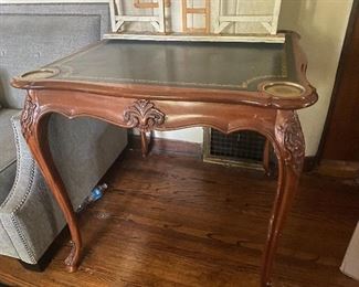 Antique card table with drink holders. Gorgeous carving on the legs.