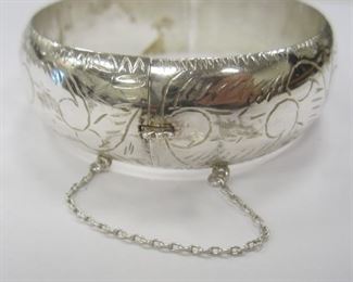 AN ETCHED HINGED CUFF BRACELET WITH SAFETY CHAIN.   MARKED 925.  HAS SOME DENTS.  SEE PHOTOS.  26.6 GRAMS