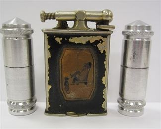 AN ANTIQUE CLARK LIFT ARM LIGHTER, PAT'D 1926. RARE WITH COPPER PLAQUE DEPICTING A SMOKER SEATED WITH A DOG ON THE SIDE. AUCTION ESTIMATE ON THIS WOULD BE FROM $30-$125
TWO ALUMINUM TUBE LIGHTERS, NEWER 2ND HALF 20TH CENTURY VERSIONS OF THE TYPE USED IN WWI