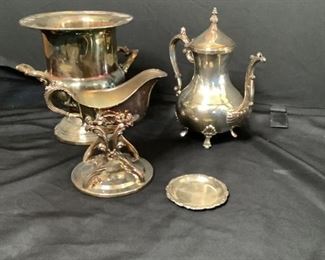 Silver plate Service Items
Three (3) silver plated service items. One champagne bucket, one gravy boat, and one teapot. Also, one small silver colored metal coaster. Champagne bucket is made by Kent. Tea pot and gravy boat made by F B Rogers. Small plate has no marking. All silver plate items show tarnishing and scratches.