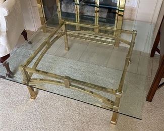 Cocktail/coffee table with brass base and glass top.