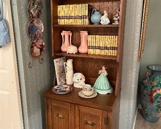1960’s oak bookcase/ cabinet w/ a set of vintage Nancy Drew books, McCoy pottery vase, Madame Alexander dolls and vintage figurines 