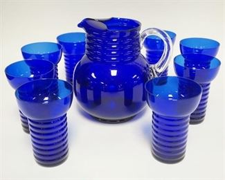 1314	COBALT BLUE DEPRESSION 9 PIECE WATER SET, HORIZONTAL RINGS, CRACK IN THE PITCHER WHERE THE BOTTOM OF THE HANDLE WAS APPLIED
