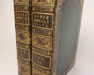 1819 The North American Sylva a Description of the Forest Trees of the United States, Canada, and Nova Scotia. Includes volumes one and two by F Andrew Michaux. Published by C D'Hautel Paris. Illustrated with 156 Coloured Engravings in each volume with tissue covers.  Has a few collected matching leaves inserted in books. Leaves have not affected the condition of the two volumes. Dark green covers with ornate gold highlights. Approximately 9-¾" by 6-¾"  
