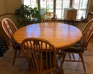solid wood kitchen table with carved claw feet, 6 Windsor chairs, and one large leaf