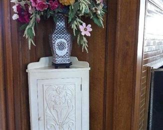 Painted wood corner cabinet and floral arrangement
