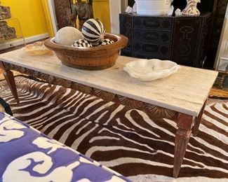 Venetian polychrome carved table with stone top; brown zebra rug