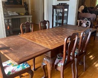 Antique dining table and matching chairs. Lion's claw foot. Solid The leaves slide under the beautiful parquetry table top.
