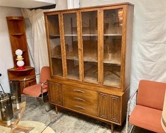 Broyhill “Sculptra” two piece display cabinet flanked by orange Herman Miller chairs