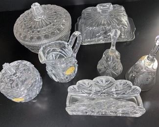 Assorted crystal are including bells, sugar bowl, napkin holder, butter dish, and creamer
