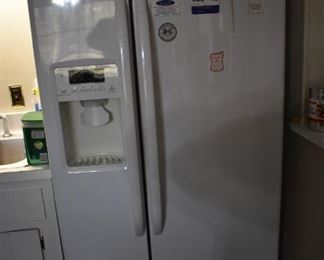 Immaculate Side by Side GE Refrigerator Freezer with lighted controls for Water Filter, Water, Crushed Ice, Cubed Ice, and Lock Control, and with many features of display in the area above the controls