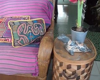 Wicker furniture is under a tent poolside now to make space for shoppers. Twin loveseats have white chenile upholstery. Shown is one of several large Guatemalan textiles on the loveseat.