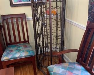 Standing caged locking wine rack with grape leaf motif : 58" tall, 17" deep and 18" across,  surrounded by upholstered Kincaid cherry slat back arm and side chair