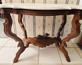 #27 - $450 Circa 1860's walnut turtle top table, original marble tops, ogee edging, with reclining dog on base. • 28high 36wide 22deep 