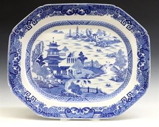 A 19th century English "Blue Willow" ironstone platter.  Octagonal form transfer decorated with Blue landscape and pagoda design.  Unmarked.  Some surface scratches, flakes to edge, staining and production glaze flaws.  20 1/2" long.  ESTIMATE $100-200

