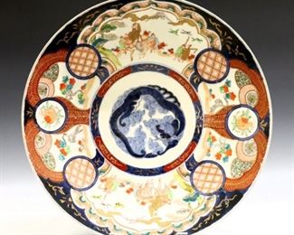 A Japanese Imari porcelain charger.  Round form decorated with central dragon surrounded by alternating pomegranate design and scenes of Mt. Fuji.  Unmarked.  Some surface scratches and minor wear to decoration.  18" diameter.  ESTIMATE $200-400
