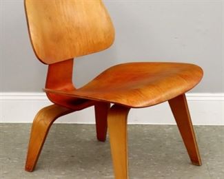 A mid 20th century Charles & Ray Eames for Herman Miller "LCW" lounge chair.  Low molded chair with Birch veneer and original Red aniline dyed finish.  Wear to dye, veneer with small chip at backrest and two hairlines at seat edge.  22 x 22 x 26 1/2" high overall.  ESTIMATE $400-600

