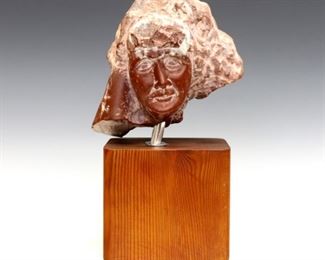 Nathan L. Fineberg, American, 20th century.  Carved Red Marble sculpture depicting a woman's face, on a fruitwood plinth.  Signed "N.L. Fineberg" and dated "1969" verso.  Some wear to finish on plinth, small metal plate loose.  Approximately 4 1/2 x 3 1/2 x 9 1/2" high overall.  ESTIMATE $100-200
