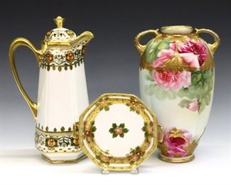 Three late 19th and early 20th century Nippon porcelain items.  Includes a 10" high two-handled vase, a 10 1/2" high chocolate pot, and a 5 1/2" diameter nut dish, all with Gilded floral designs.  Vase with "maple leaf" printed mark, pot and dish with "RC" Royal Crockery.  Each with some wear to surface and decoration, vase with some discoloration, insert of pitcher lid repaired and repainted.  ESTIMATE $200-300
