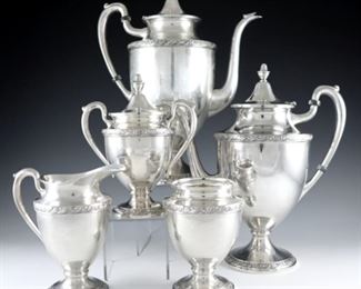A F.B. Rogers Sterling Silver tea set.  Includes an 11" high coffee pot, a 10 1/2" high teapot, a 7" high covered waste bowl, a 5 3/4" high creamer, and 5" sugar.  Impressed "FB Rogers Silver Co" "Sterling" with "402" pattern number.  51.59 troy ozs total weight.  Minor surface wear, coffee pot and waste bowl with dents, slight damage to glass accents on handles.  ESTIMATE $1,200-1,500
