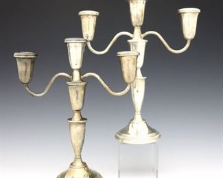 A pair of "Empress" Sterling Silver candelabra.  Three part weighted convertible candelabra with two arms and gadrooned edges.  Impressed "Empress Sterling Weighted".  Some surface wear, one with dents to base.  8" to 11" high.  ESTIMATE $100-200
